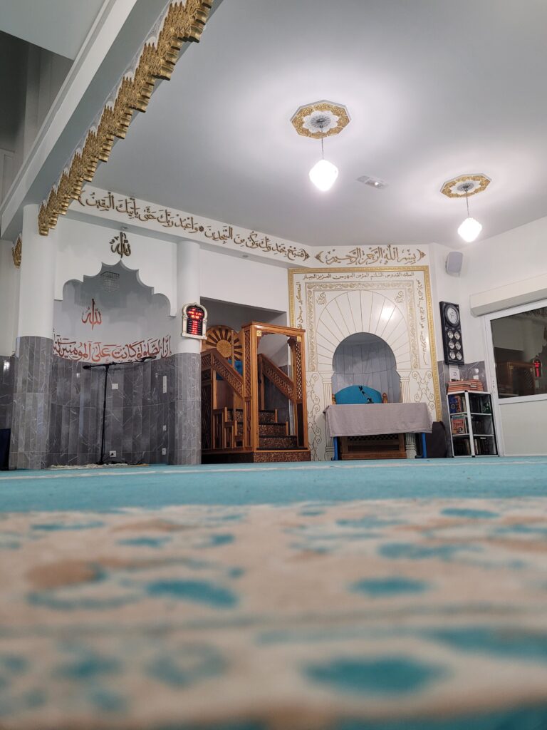 Vue de l'intérieur de la Grande Mosquée de Narbonne avec son architecture élégante et son espace dédié à la prière.